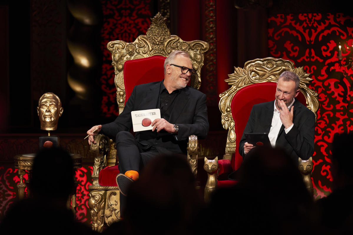 Greg Davies and Alex Horne share a laugh in their comically-sized throne chairs next to a golden statue of Davies’ head on the set of Taskmaster.