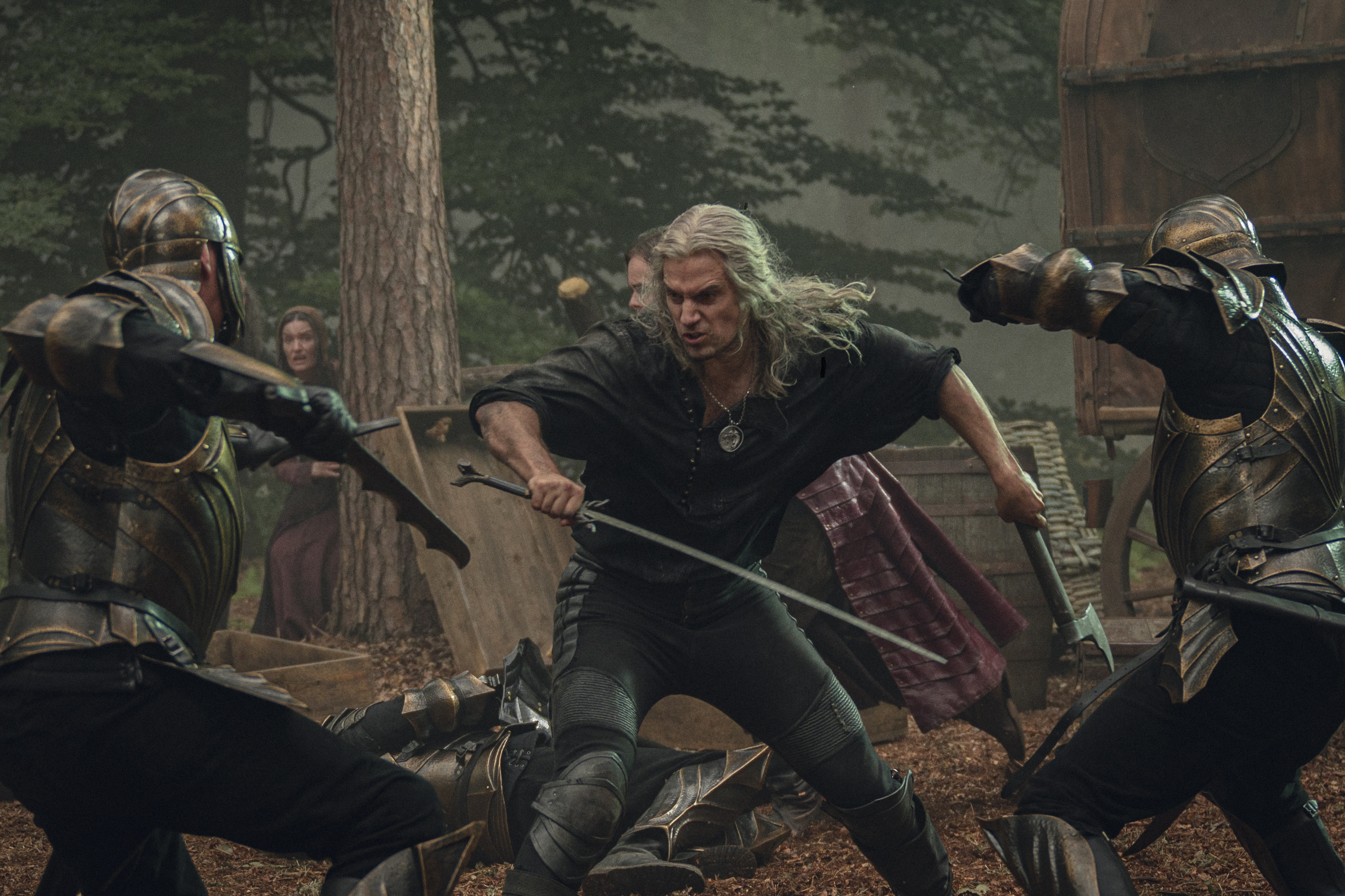 Geralt (Henry Cavill) mid fight with a couple Nilfgaardian soldiers