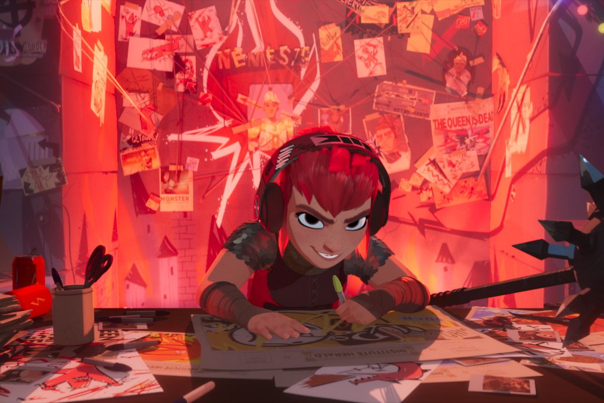 A red-haired animated girl with a mischievous smile on her face wearing headphones hunches over a desk while drawing on a piece of paper in Nimona.