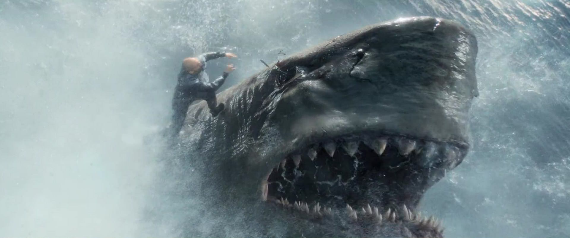 Jonas Taylor (Jason Statham) stabbing a megalodon shark in the eye with a spear in The Meg.