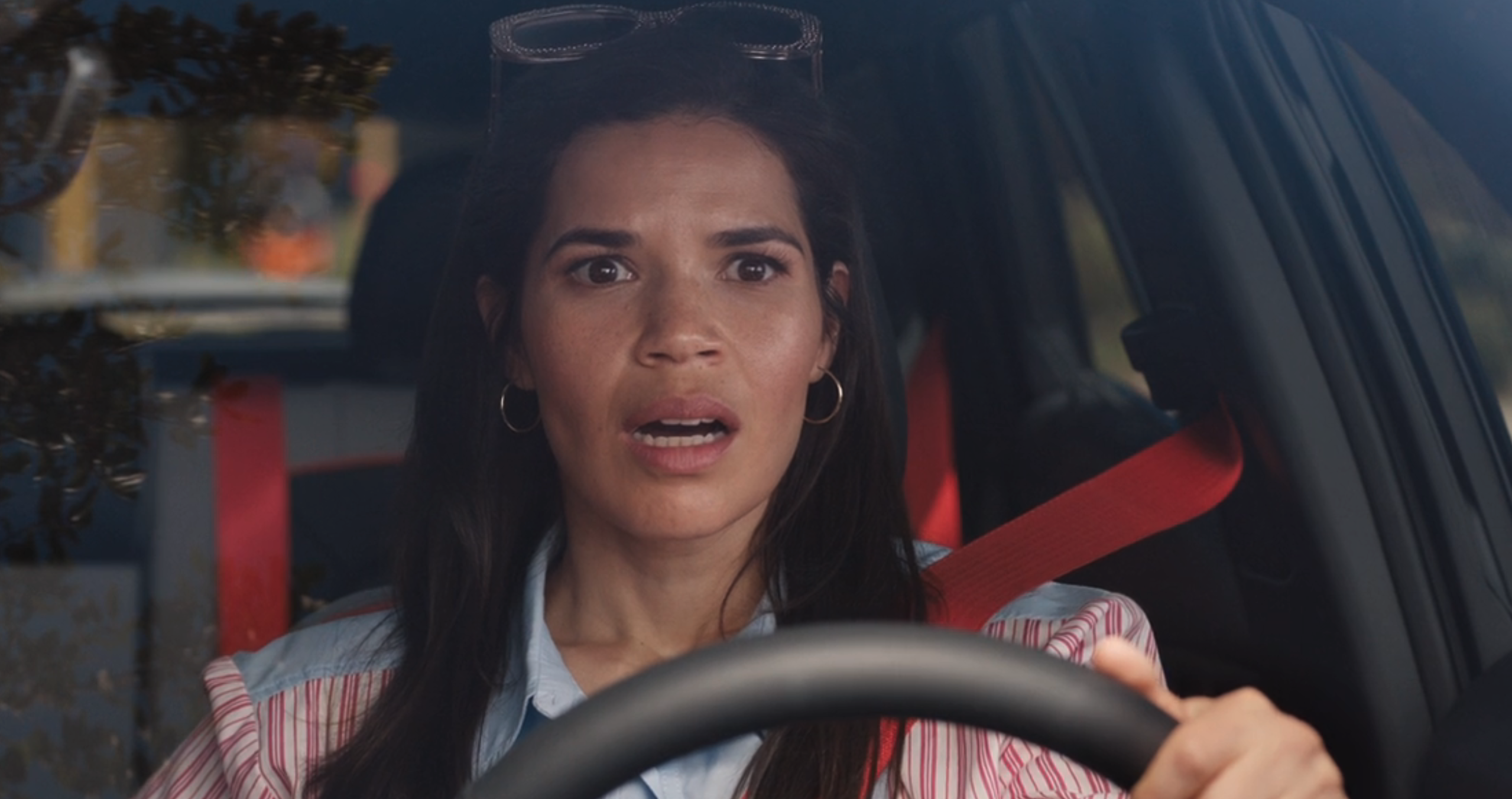 America Ferrera in Barbie, sitting in a car and looking shocked