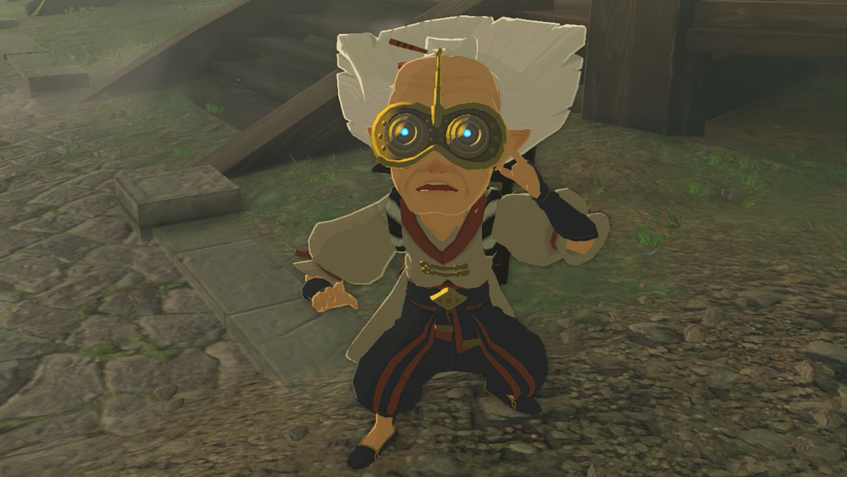 The Legend of Zelda: Tears of the Kingdom’s Robbie stands in a slight squat looking straight ahead, with his left hand touches his face.